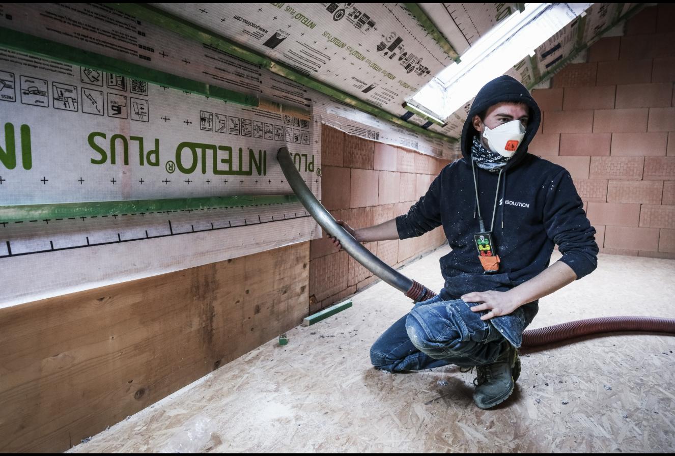 Ouvrier Isolution réalisant l'isolation des murs par l'intérieur par insufflation avec pare-vapeur Intello Plus
