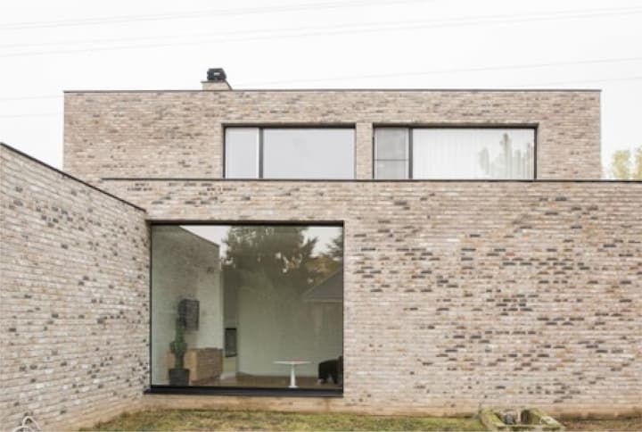 Photo de la façade avant d'une maison avec un mur en briquettes